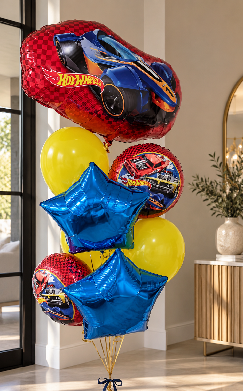 Bright kids' birthday helium balloon bouquet featuring red Hot Wheels racing car foil balloons, metallic electric blue star balloons, and vibrant yellow helium balloons. Colorful racing-themed birthday surprise by Best Balloons LA, offering kids' birthday balloon delivery in Beverly Hills, Bel Air, Brentwood, and Los Angeles.