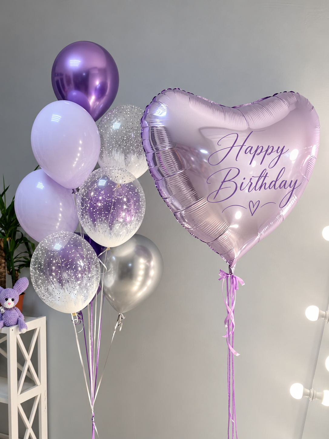 Elegant lavender and silver helium birthday balloon bouquet featuring a large metallic lilac heart-shaped foil balloon with personalized Happy Birthday lettering, deep purple chrome balloons, pastel lavender balloons, silver metallic accents, and clear sparkling balloons. Luxury birthday balloon delivery by Best Balloons LA in Beverly Hills, Bel Air, Brentwood, and Los Angeles.