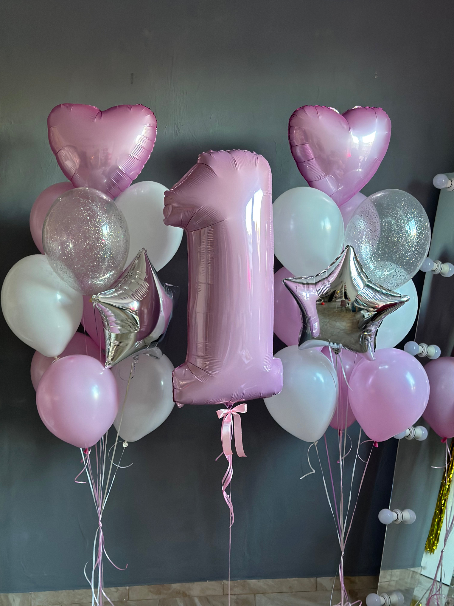 Elegant pink first birthday helium balloon arrangement featuring a large pastel pink number 1 foil balloon, metallic pink heart balloons, silver star balloons, pearl white and baby pink latex balloons, and clear sparkling balloons. Sweet One birthday decoration for girls by Best Balloons LA, offering luxury birthday balloon delivery in Beverly Hills, Bel Air, Brentwood, and Los Angeles.